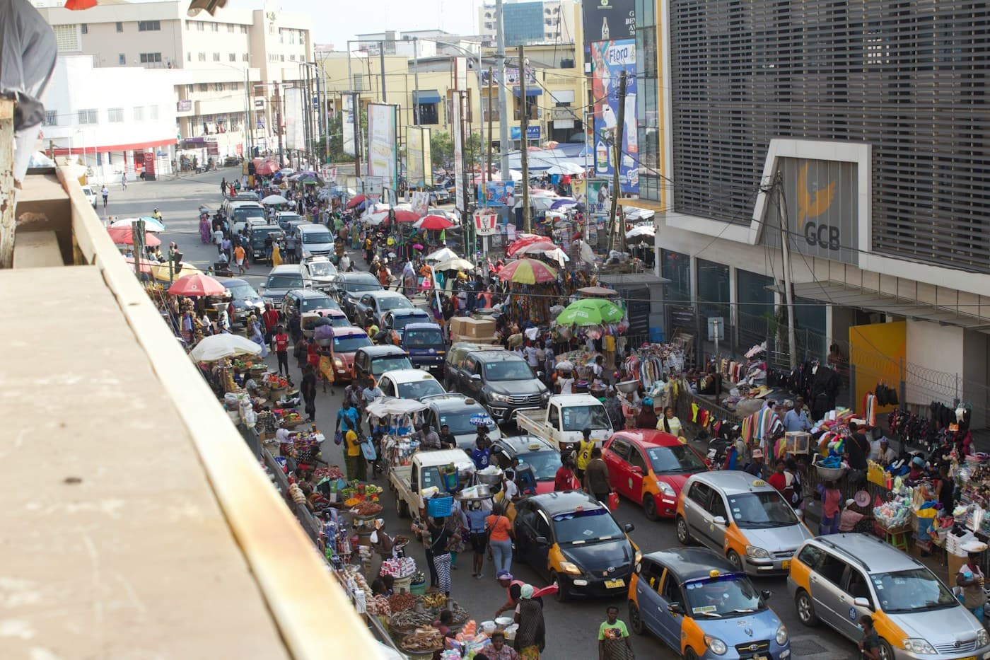 A busy market street in Accra, packed with stalls and taxis